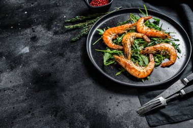 Izgara dev kaplan karidesli salata, karides ve roka. Siyah arka plan. Üst Manzara. Boşluğu kopyala