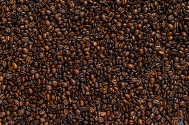 Kırsal masada kavrulmuş kahve çekirdekleri. Siyah arka plan. Üst görünüm