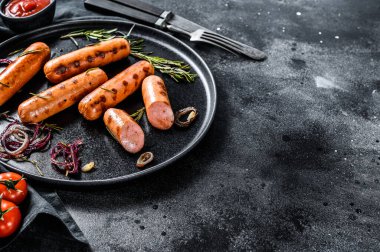 Izgara domuz sosisi soğanlı, sarımsaklı ve biberiyeli. Siyah arka plan. Üst Manzara. Boşluğu kopyala