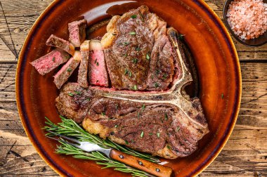 Barbekü rosto ya da sığır eti bifteği kırsal bir tabakta. Ahşap arka plan. Üst görünüm