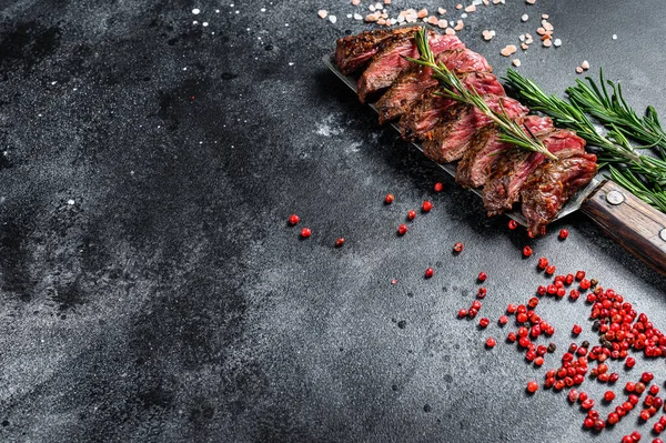 Grilled Vegas strip steak. Marble meat beef. Black background. Top view. Copy space