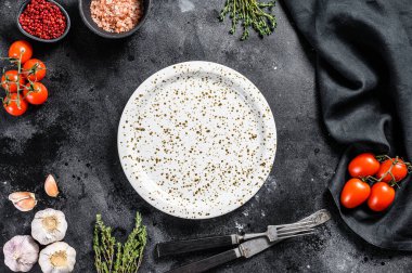Taze çiğ sebze ve sebzelerin ortasında beyaz boş bir tabak. Sağlıklı, temiz yemek, vejetaryen, diyet yemek konsepti. Siyah arka plan. Üst Manzara. Boşluğu kopyala