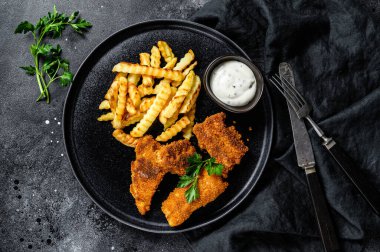 Balık ve patates kızartması, geleneksel İngiliz yemekleri. Siyah arka plan. Üst görünüm