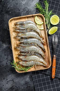 Taze çiğ kaplan karidesleri, tahta tepside karides. Siyah arka plan. Üst görünüm