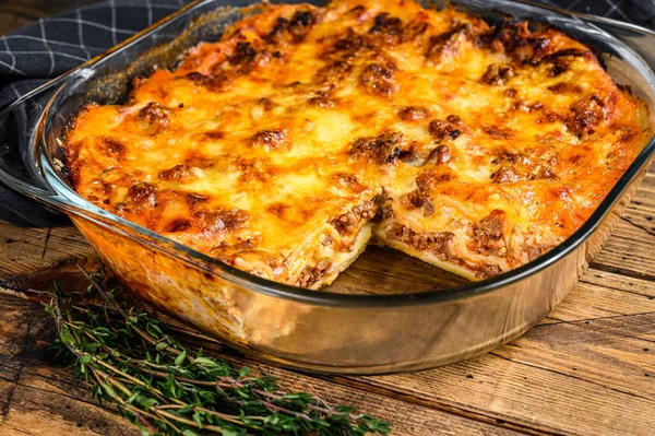 Lasagna with bolognese sauce and mince beef in a baking dish. Wooden background. Top view — Stock Photo, Image