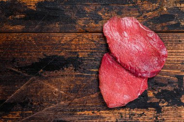 Çiğ siyah angus bifteği. Koyu ahşap arka plan. Üst Manzara. Boşluğu kopyala