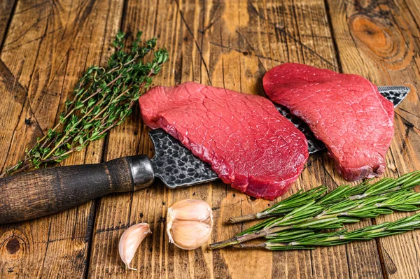 Kasap bıçağının üstüne çiğ sığır eti sığır filetosu. Ahşap arka plan. Üst görünüm — Stok fotoğraf