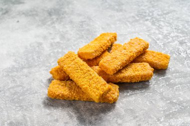 Donmuş balık çubukları. Organik balık yemi. Gri arka plan. Üst görünüm