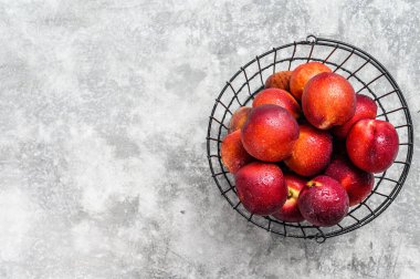 Sepette olgun kırmızı nektarinler. Gri arka plan. Üst Manzara. Boşluğu kopyala