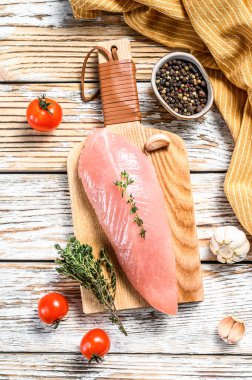 Kesme tahtasında çiğ hindi göğsü. Biftek. Beyaz ahşap arka plan. Üst görünüm