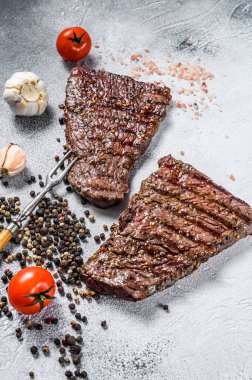 Baharatlı ızgara biftek. Barbekü bifteği. Gri arka plan. Üst görünüm