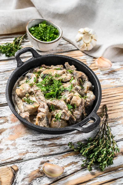 Kızartma tavasında mantarlı biftek stroganoff. Beyaz arka plan. Üst görünüm