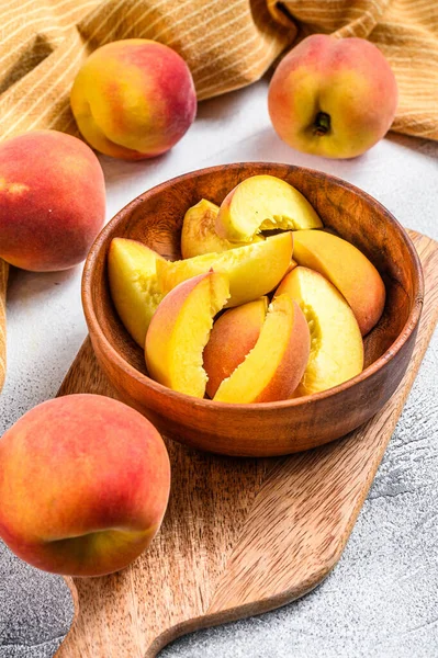 Sliced Peaches, organic fruit in a wooden bowl. Gray background. Top view — Stock Photo, Image