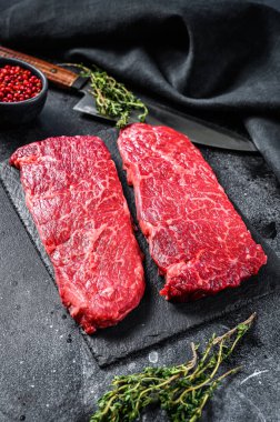 Denver bifteği ve şifalı bitkiler. Organik et. Siyah arka plan. Üst görünüm.