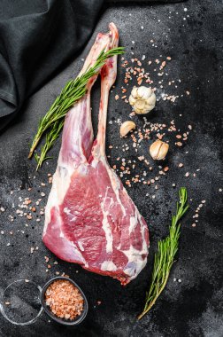 Çiğ keçi bacağı ve tuz ve sarımsak. Çiftlik eti. Siyah arka plan. Üst görünüm