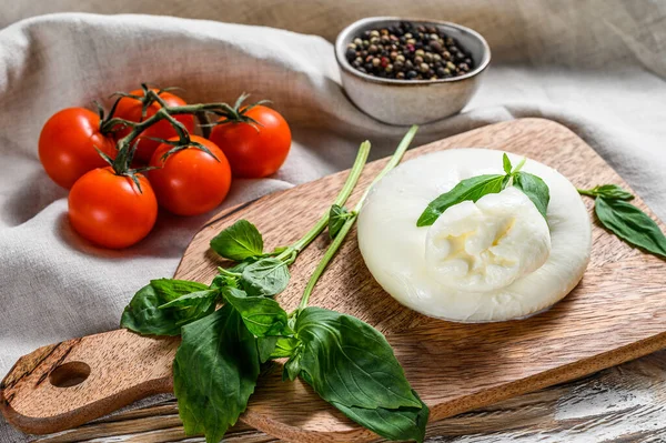 Formaggio di bufala burrata italiano con foglie di basilico. Fondo in legno bianco. Vista dall'alto — Foto Stock