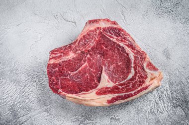 Çiğ kovboy bifteği ya da kemiğe pirzola. Mermer biftek. Gri arka plan. Üst görünüm