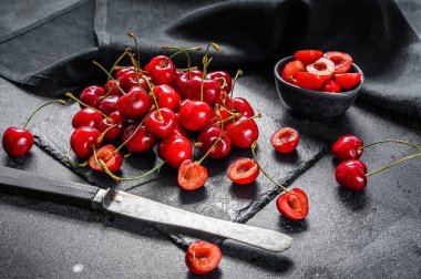 Siyah kesme tahtasında kırmızı kiraz. Taze kirazlar. Siyah arka plan. Üst görünüm
