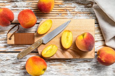 Taze şeftali, doğrama tahtasında organik meyve. Beyaz ahşap arka plan. Üst görünüm