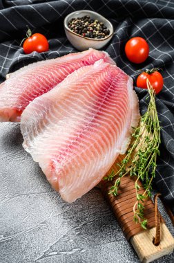 Kesme tahtasında kekik ve pembe biberli tilapia fileto. Beyaz arka plan. Üst görünüm