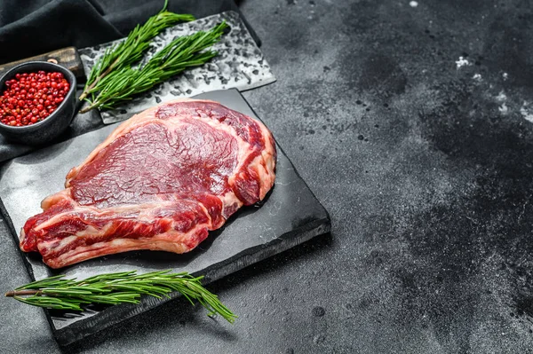 Bife de cowboy cru. Carne de vaca de mármore no ribeye osso. Fundo preto. Vista superior. Espaço de cópia — Fotografia de Stock