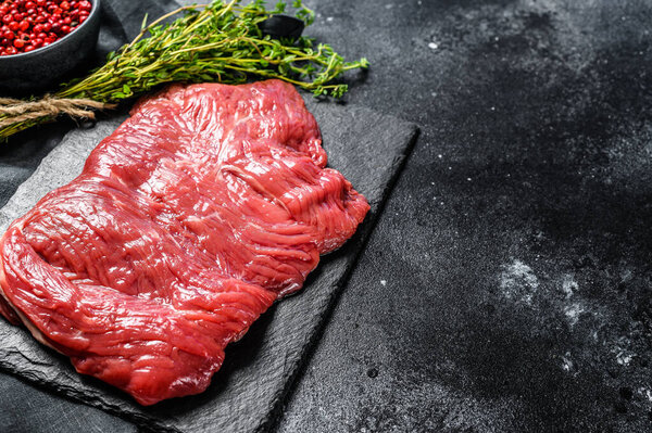 Raw flank steak, marbled meat. Black background. Top view. Copy space