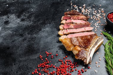 Kemiğe tuz ve biberli pirzola. Izgara sığır eti. Siyah arka plan. Üst Manzara. Boşluğu kopyala