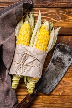 Çiftçi pazarında taze mısır koçanı, yerel sebzeler. Ahşap arka plan. Üst görünüm