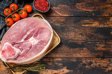 Çiğ domuz budu, bacağı kesme tahtasının üzerinde. Taze çiftlik eti. Ahşap arka plan. Üst Manzara. Boşluğu kopyala