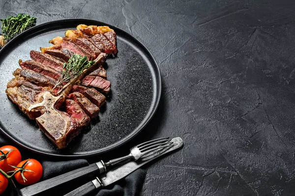 Gegrilde Porterhouse biefstuk op een bord. Gekookt rundvlees. Witte houten achtergrond. Bovenaanzicht. Kopieerruimte. — Stockfoto