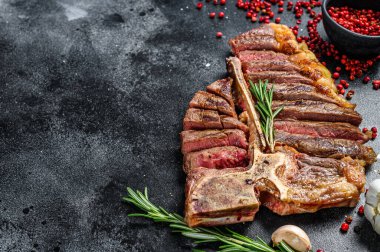 Dilimlenmiş ızgara biftek. Pişmiş tbone bifteği. Siyah arka plan. Üst Manzara. Boşluğu kopyala