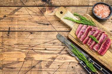 Kesme tahtasındaki sığır filetosundan madalyon bifteği. Ahşap arka plan. Üst Manzara. Boşluğu kopyala