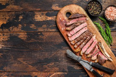 Kemiğe pirzola. Izgara sığır eti. Ahşap arka plan. Üst Manzara. Boşluğu kopyala