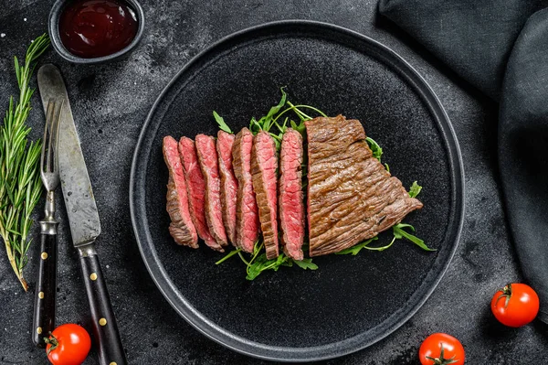 Gegrilde en gesneden biefstuk. Marmeren rundvlees. Zwarte achtergrond. Bovenaanzicht — Stockfoto