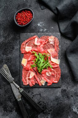 İtalyan etli carpaccio roka salatası, parmesan peyniri. Siyah arka plan. Üst görünüm
