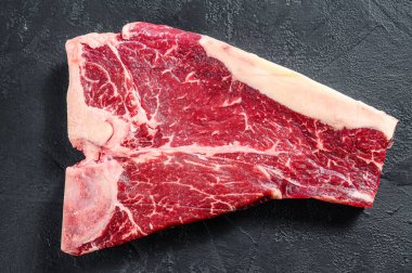 Kalın Raw T-Bone bifteği. Siyah arka plan. Üst görünüm