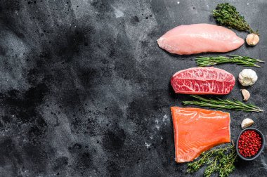 Farklı türde otlu çiğ et. Biftek bıçağı, somon filetosu ve hindi göğsü. Biftek. Siyah arka plan. Üst Manzara. Boşluğu kopyala