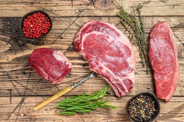 Taze çiğ siyah angus bifteği fileto Mignon, pirzola ya da kovboy, Striploin. Ahşap arka plan. Üst görünüm