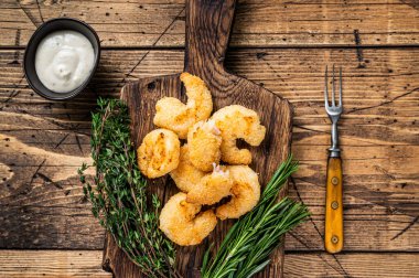 Tahta tahtada soslu kızarmış karides karidesi. Ahşap arka plan. Üst görünüm