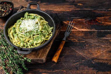 Pesto soslu spagetti makarna, ıspanak ve parmesan. Karanlık ahşap arka plan. Üst Manzara. Boşluğu kopyala
