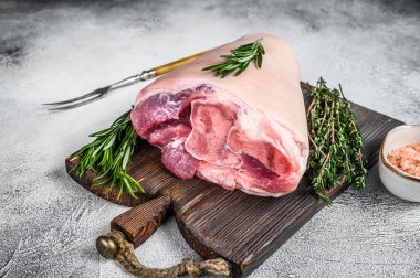 Bitkilerle yemek pişirmek için çiğ domuz budu. Beyaz arka plan. Üst görünüm