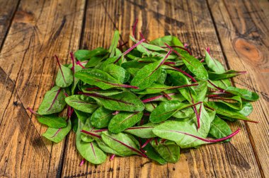 Taze çiğ pazı yaprakları, mangold, ahşap mutfak masasında İsviçre pazısı. Ahşap arka plan. Üst görünüm