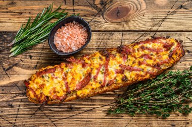 Jambonlu, jambonlu, sebzeli ve peynirli pizza sandviçi. Ahşap arka plan. Üst görünüm