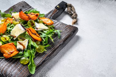 Fırında kabak ve peynirli sonbahar salatası. Sağlıklı vejetaryen gıda konsepti. Beyaz arka plan. Üst Manzara. Boşluğu kopyala