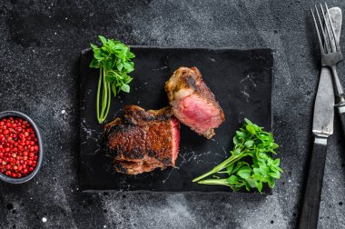 Izgara Striploin veya New York bifteği. Siyah arka plan. Üst görünüm