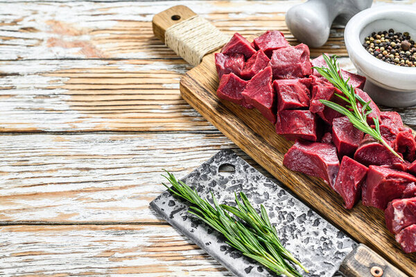 Cut Pieces of Raw beef liver offal. White wooden background. Top view. Copy space