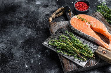 Tahta kesim tahtasında çiğ somon balığı bifteği. Siyah arka plan. Üst Manzara. Boşluğu kopyala