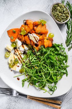 Roka salatası, fırında kabak ve peynir. Beyaz arka plan. Üst görünüm