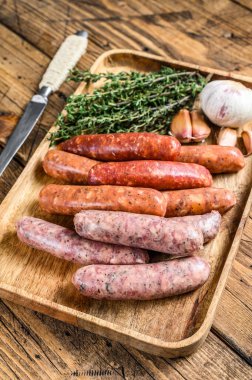 Çiğ sosis varyasyonu, sığır eti ve domuz eti. Ahşap arka plan. Üst görünüm