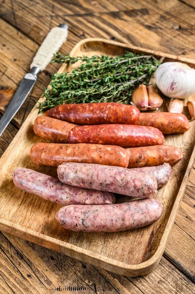 Çiğ sosis varyasyonu, sığır eti ve domuz eti. Ahşap arka plan. Üst görünüm